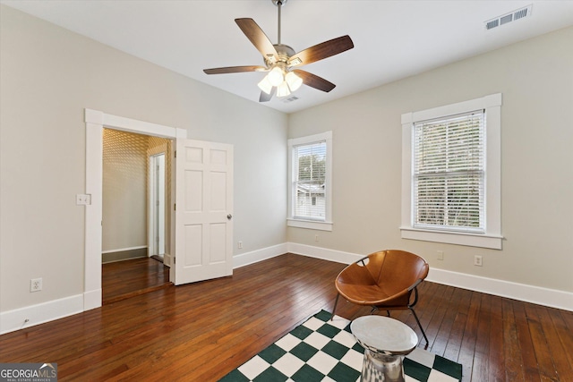 sitting room with dark wood-type flooring and ceiling fan