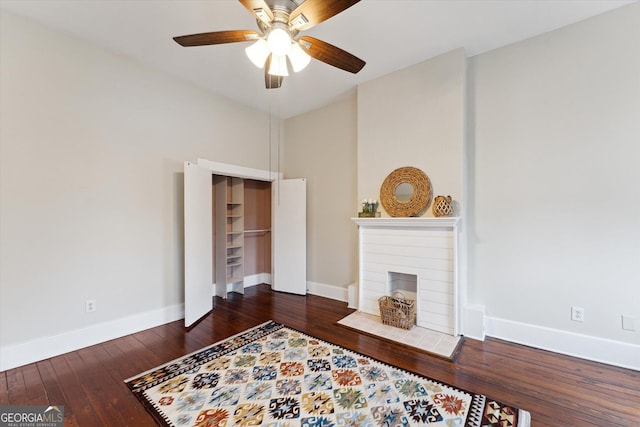 living room featuring dark wood-type flooring and ceiling fan