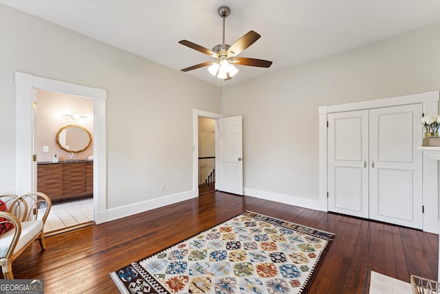 bedroom with ensuite bathroom, dark hardwood / wood-style floors, ceiling fan, and a closet