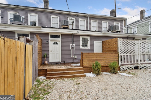 rear view of house with central AC and a deck