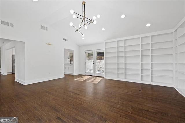 unfurnished living room featuring built in features, high vaulted ceiling, a chandelier, dark hardwood / wood-style flooring, and french doors