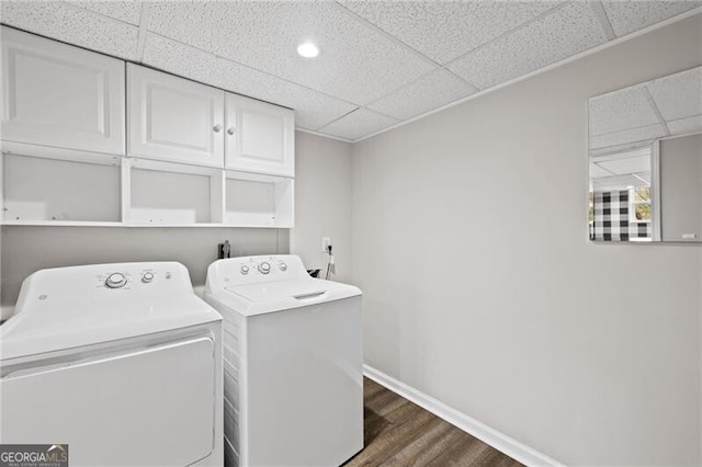 laundry area featuring cabinets, dark hardwood / wood-style floors, and washer and clothes dryer