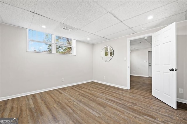 basement featuring wood-type flooring and a paneled ceiling