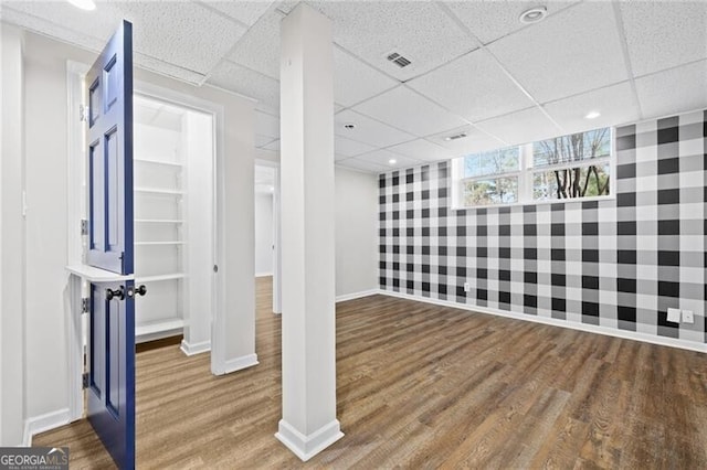 basement with hardwood / wood-style flooring and a drop ceiling