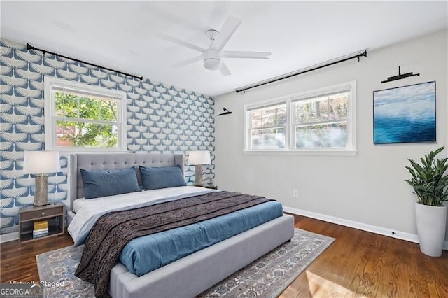 bedroom featuring multiple windows, dark hardwood / wood-style floors, and ceiling fan