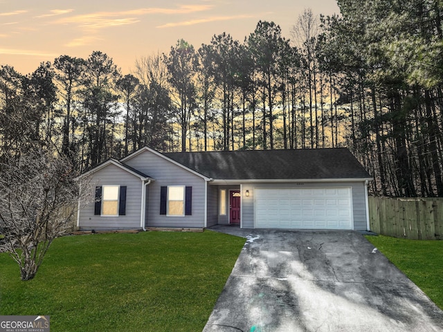 ranch-style house with a garage and a lawn