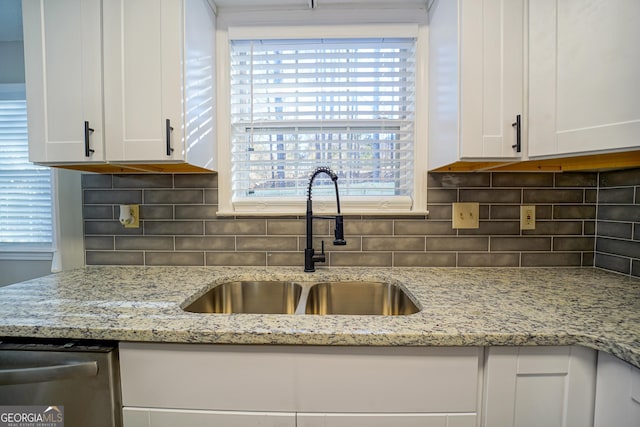 kitchen with white cabinetry, sink, light stone countertops, and dishwasher