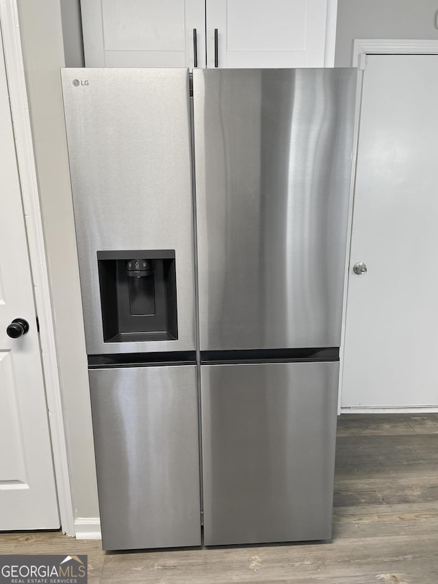 kitchen with hardwood / wood-style flooring, white cabinets, and stainless steel refrigerator with ice dispenser