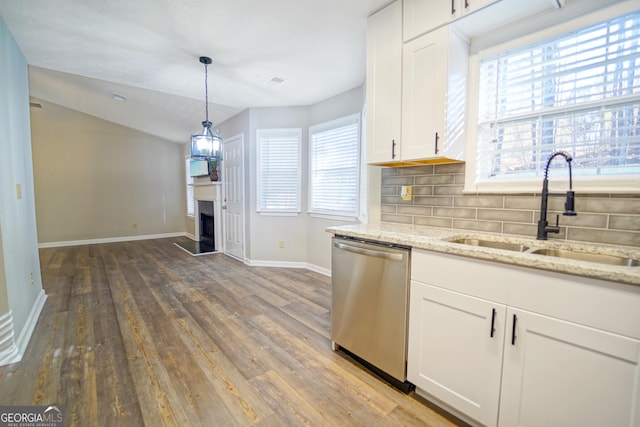 kitchen featuring tasteful backsplash, dishwasher, sink, white cabinets, and light stone counters