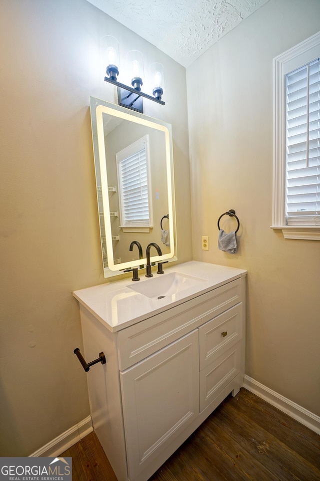 bathroom featuring hardwood / wood-style flooring, vanity, and a textured ceiling