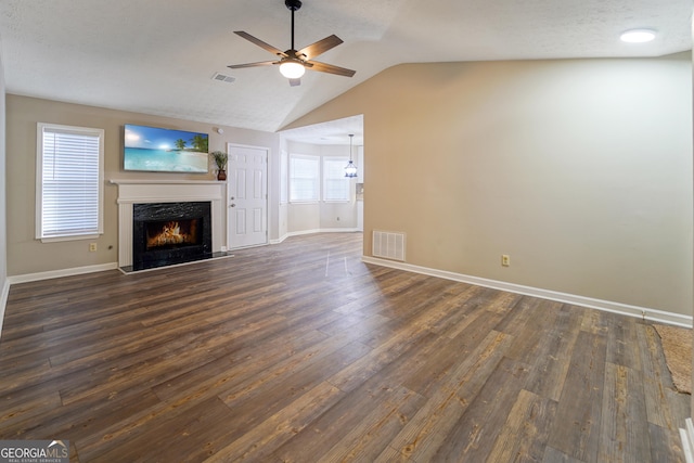 unfurnished living room featuring a premium fireplace, lofted ceiling, dark hardwood / wood-style floors, and ceiling fan