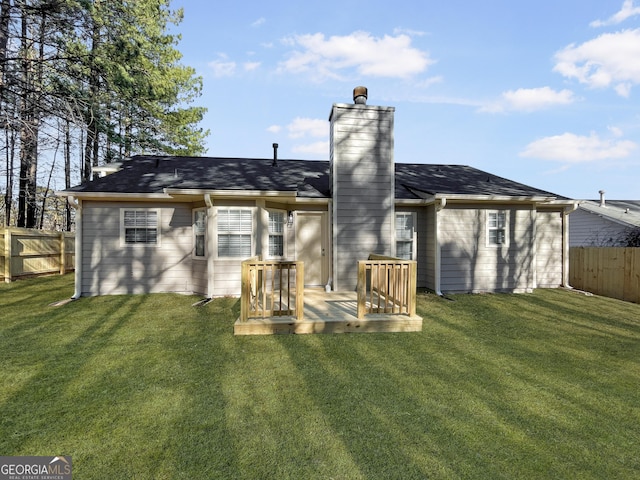 rear view of house featuring a yard and a deck