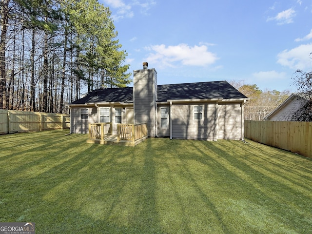 back of property featuring a deck and a lawn