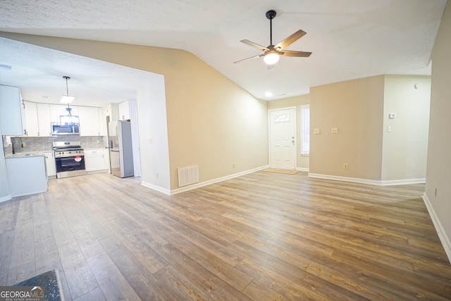 unfurnished living room with hardwood / wood-style flooring, ceiling fan, and lofted ceiling