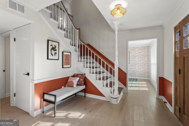 foyer entrance featuring crown molding and hardwood / wood-style floors