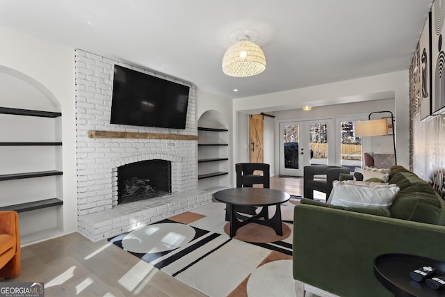 living room featuring french doors, a fireplace, and built in features