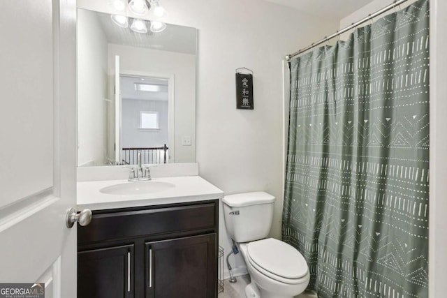 bathroom with walk in shower, vanity, and toilet