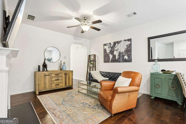 living area with ceiling fan and dark hardwood / wood-style flooring