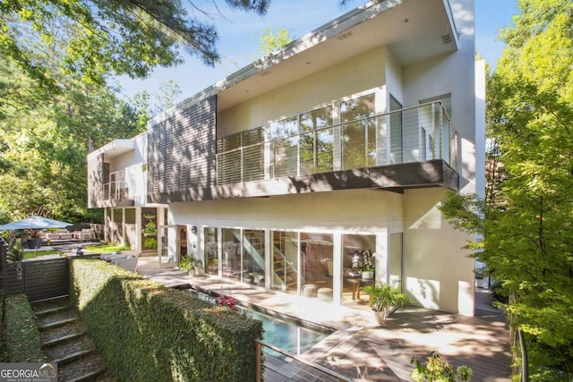 back of property featuring a balcony and a patio