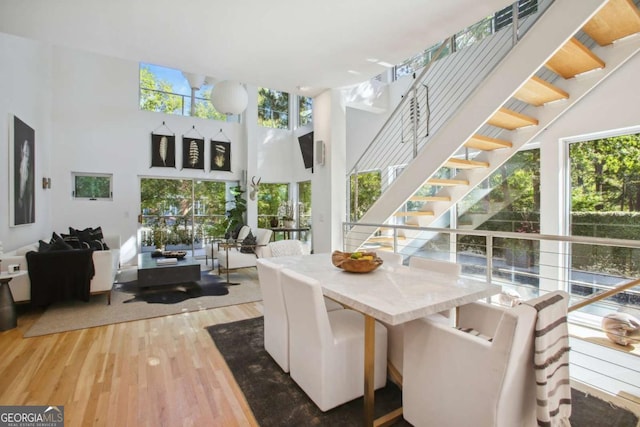 dining area featuring hardwood / wood-style flooring and a high ceiling