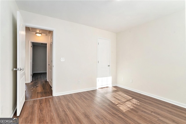 unfurnished room featuring dark wood-type flooring