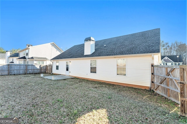 back of house with a yard and a patio