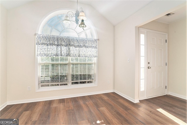 entrance foyer with lofted ceiling, a chandelier, and dark hardwood / wood-style flooring