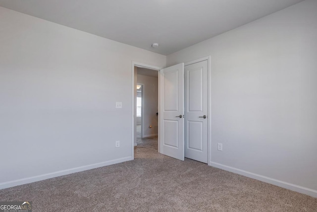 unfurnished bedroom featuring light carpet