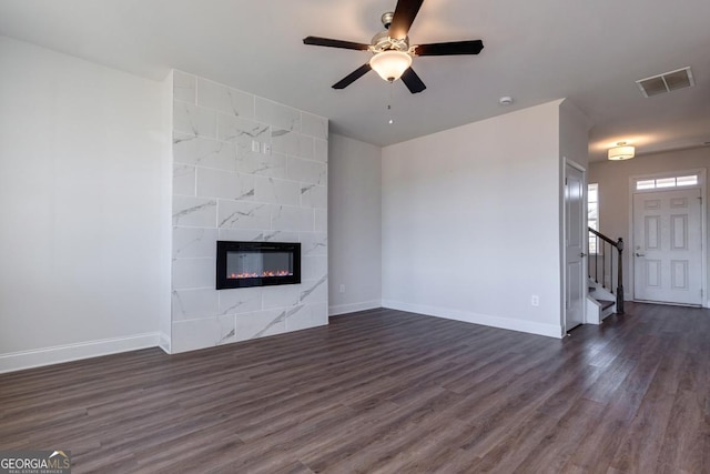 unfurnished living room with ceiling fan, dark hardwood / wood-style floors, and a high end fireplace