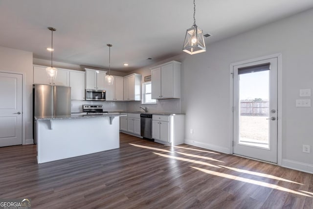 kitchen with hanging light fixtures, a center island, white cabinets, and appliances with stainless steel finishes