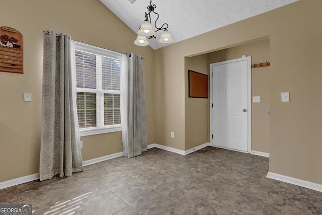 spare room with an inviting chandelier, a healthy amount of sunlight, and lofted ceiling