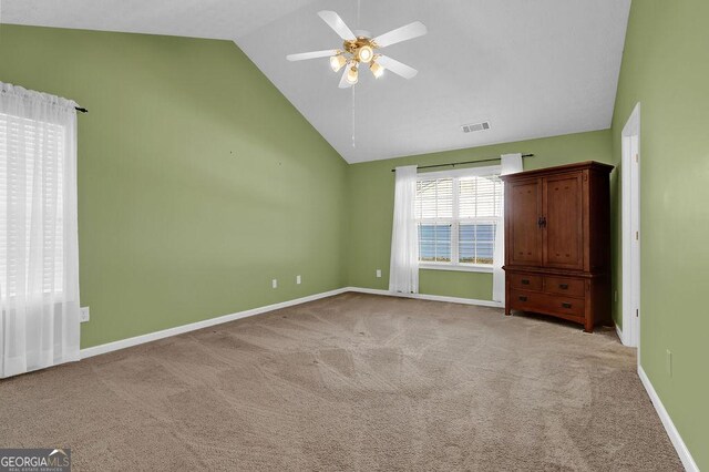 unfurnished bedroom featuring light carpet, high vaulted ceiling, and ceiling fan