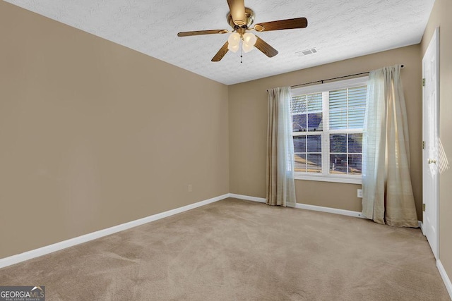 carpeted spare room with ceiling fan and a textured ceiling