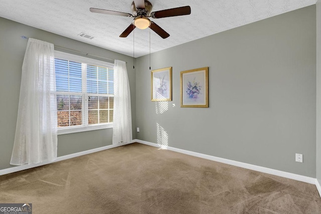 carpeted spare room with ceiling fan and a textured ceiling