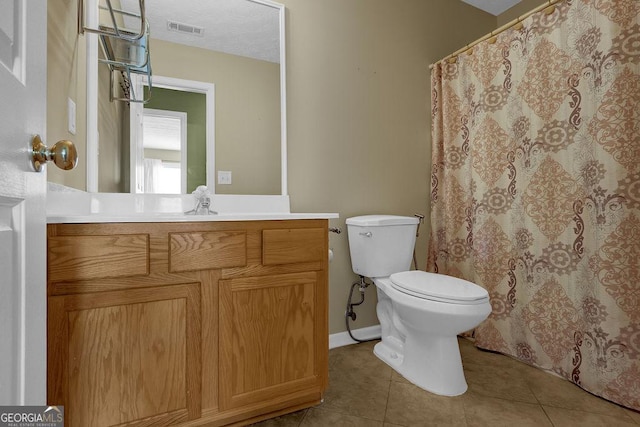 bathroom with vanity, toilet, tile patterned flooring, and a textured ceiling