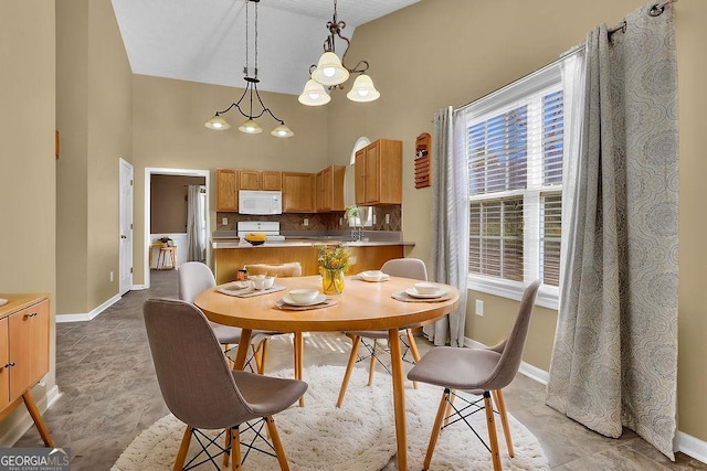 dining area featuring a chandelier and high vaulted ceiling