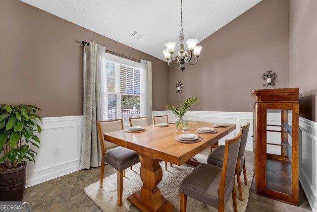 dining room with lofted ceiling and an inviting chandelier