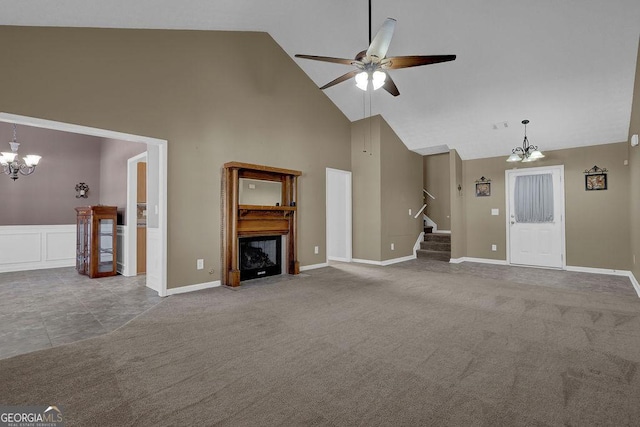 unfurnished living room featuring carpet floors, ceiling fan with notable chandelier, and high vaulted ceiling