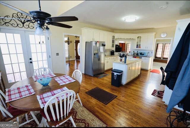 kitchen featuring french doors, white cabinetry, wood-type flooring, a center island, and stainless steel fridge with ice dispenser