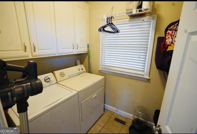 washroom with cabinets, light tile patterned floors, and washer and clothes dryer