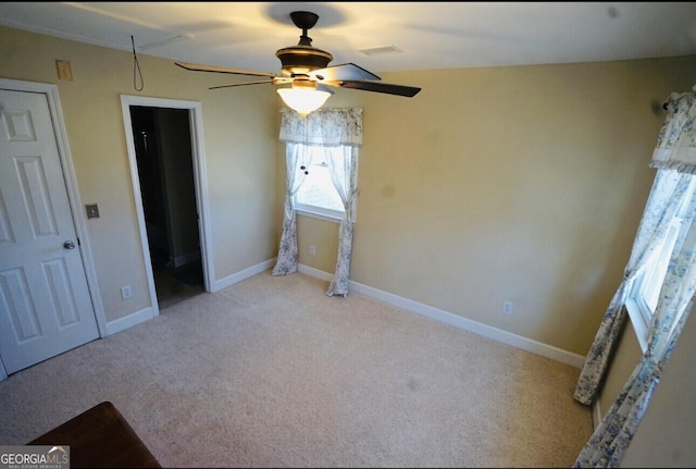 unfurnished bedroom with light colored carpet and ceiling fan