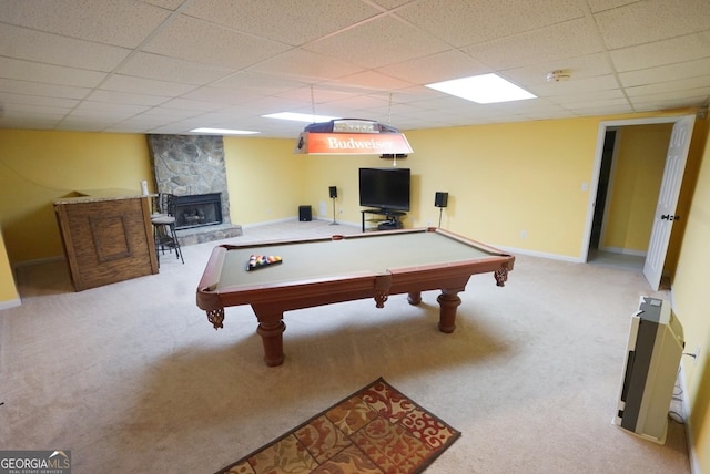 recreation room with light colored carpet, a stone fireplace, a paneled ceiling, and pool table