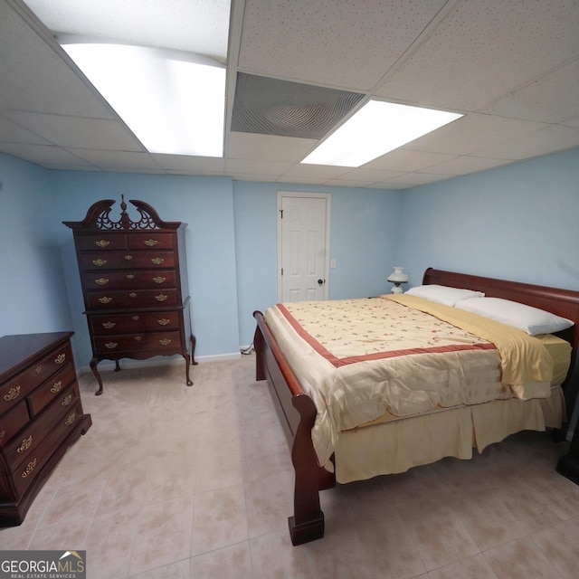 bedroom with light tile patterned floors and a paneled ceiling