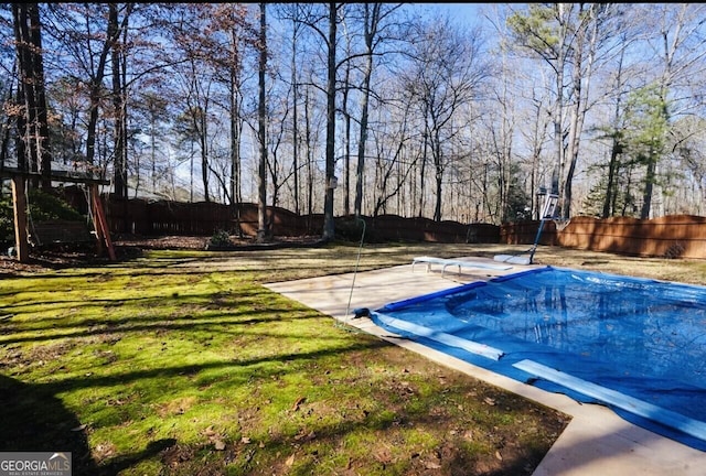 view of pool with a patio, a yard, and a diving board