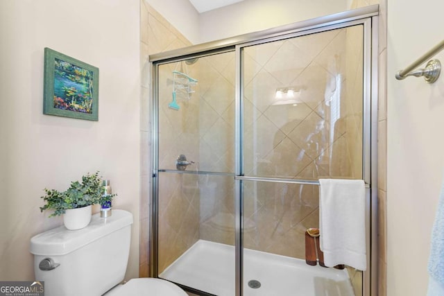 bathroom with a shower with door and toilet