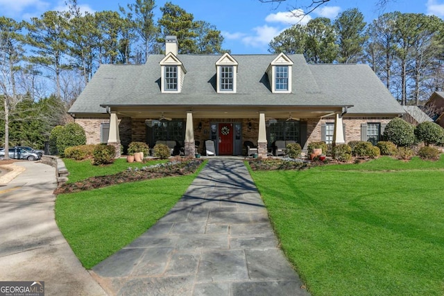 new england style home featuring a porch and a front yard