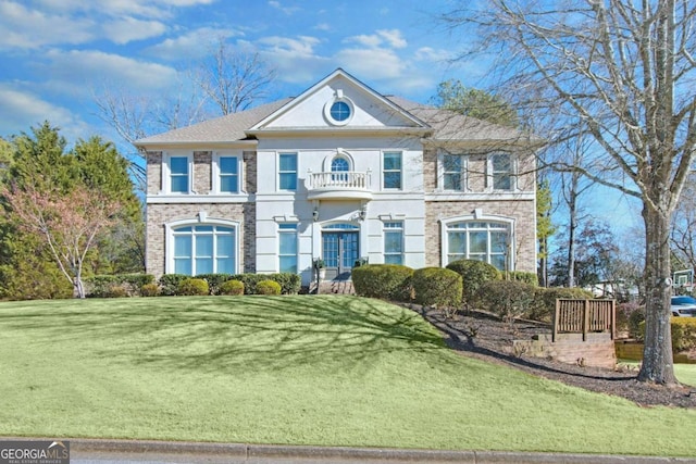 view of front of property with a balcony and a front lawn