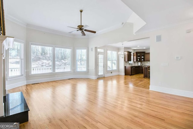 unfurnished living room featuring ceiling fan, ornamental molding, and light hardwood / wood-style flooring