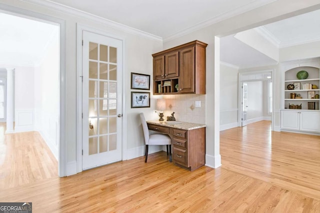 bar with crown molding, built in features, light hardwood / wood-style floors, and decorative backsplash