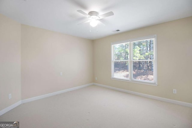 carpeted spare room with ceiling fan